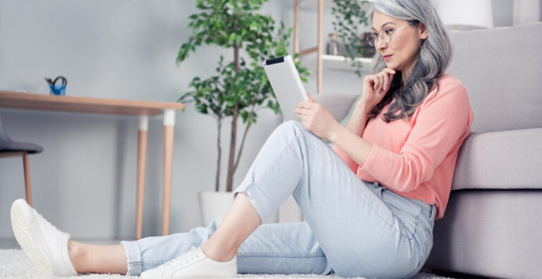 A woman in midlife reads about testosterone for menopausal women and the FDA meeting on her tablet at home