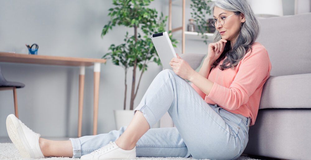 A woman in midlife reads about testosterone for menopausal women and the FDA meeting on her tablet at home