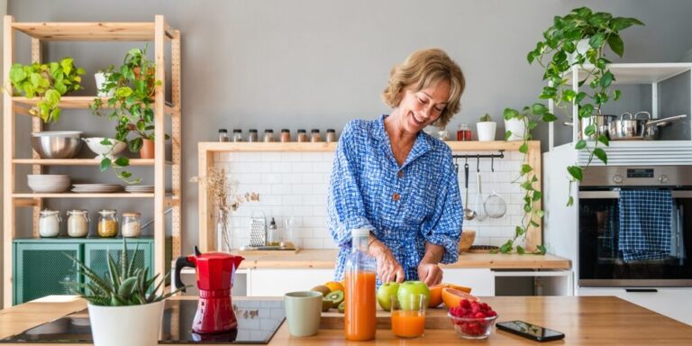 Midlife woman preparing a healthy meal with fresh fruit in her kitchen