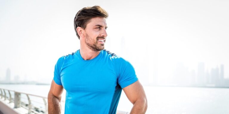 Fit man in his forties smiling outdoors after a workout